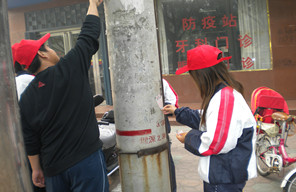 志愿者在清理线杆上小广告